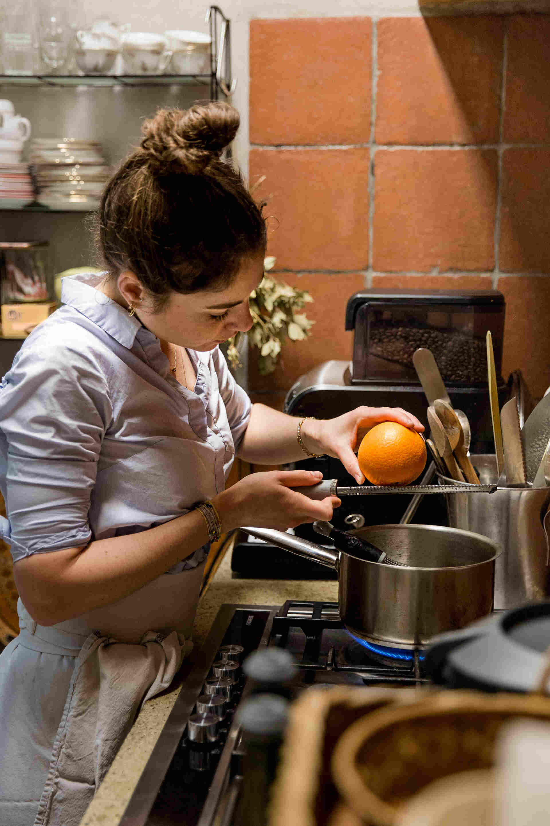 Ella rappant une orange dans une casserole remplie d'eau