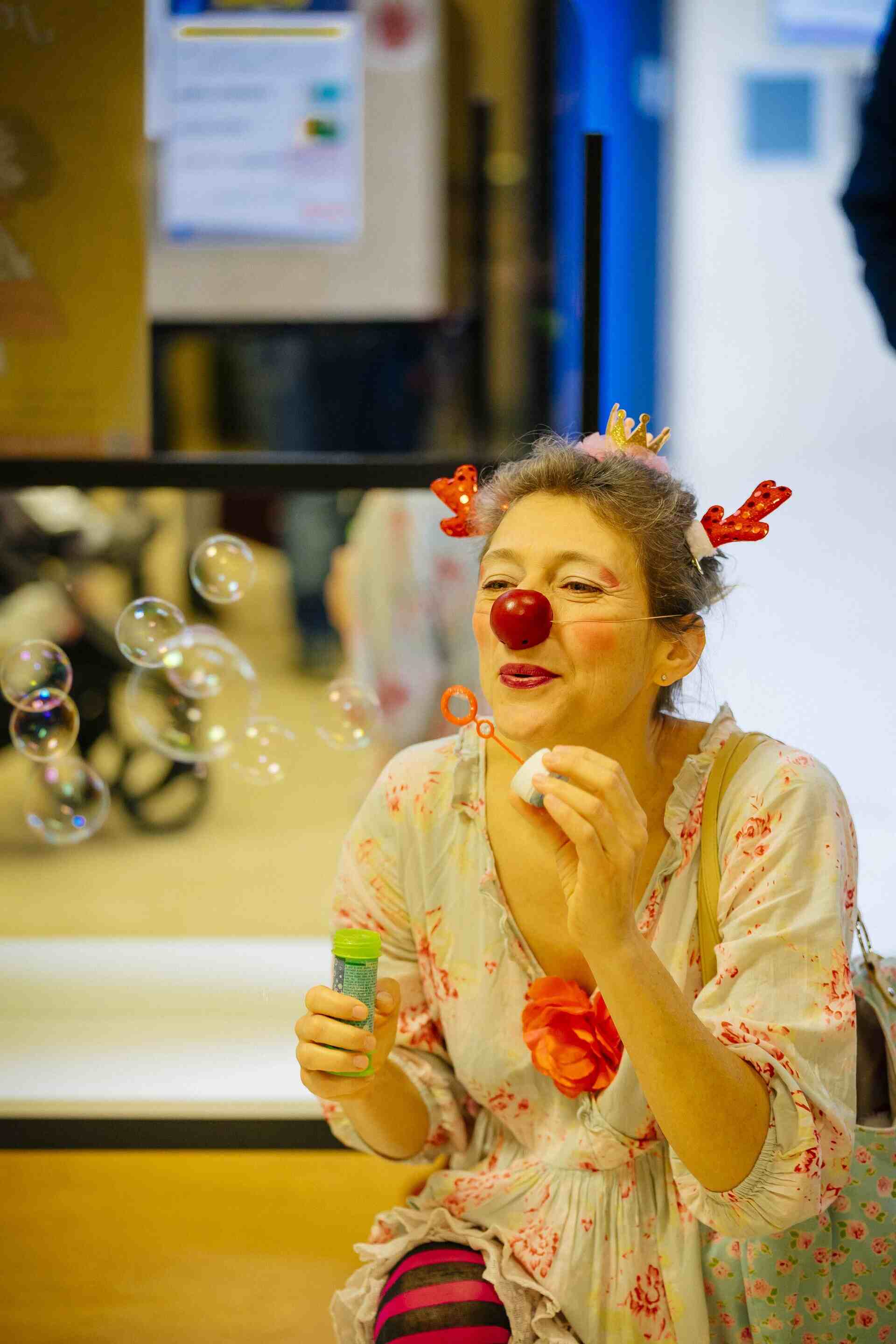Fabienne en clown d'hopital qui souffle dans un baton de bulle à savon